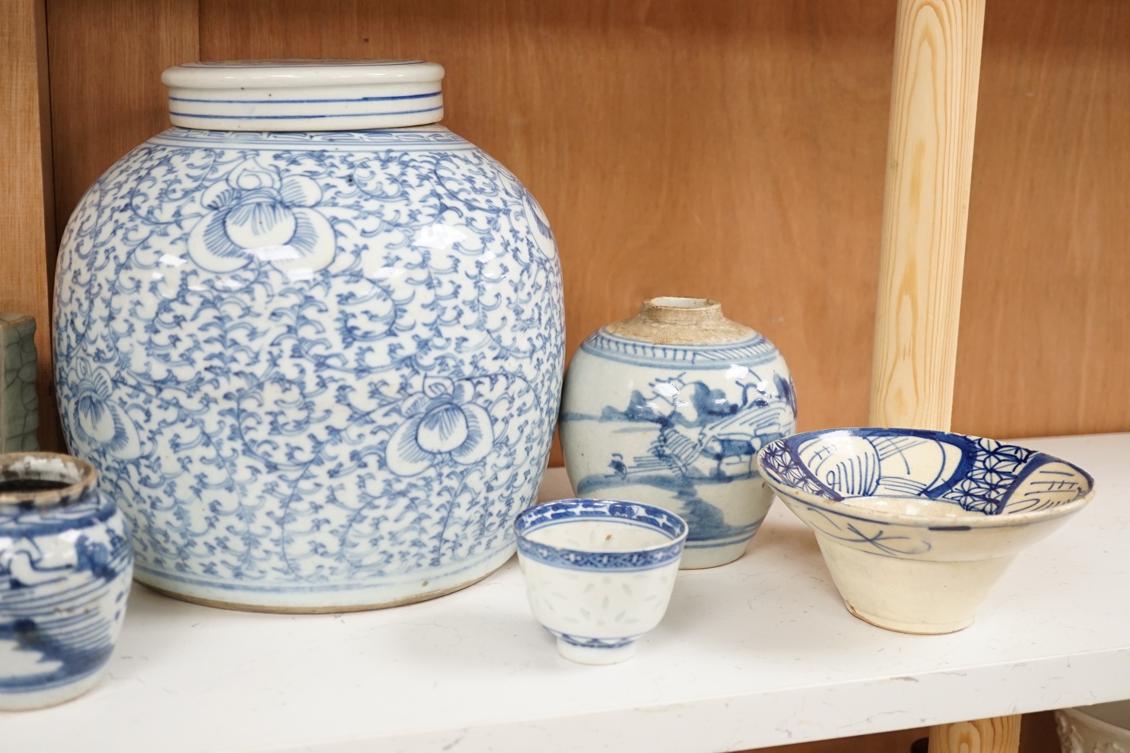 A group of 19th century blue and white jars, a stacking food box and two bowls, together with a celadon glazed cong vase and a soapstone figure of Liu Hai. Tallest 24cm